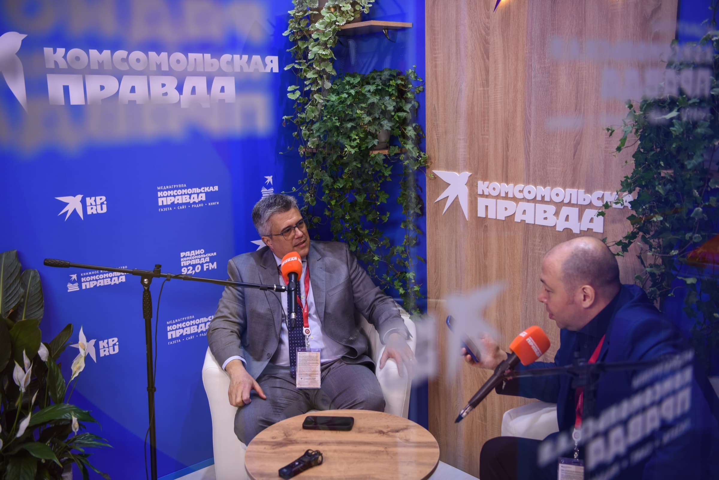 El Dr. Alexei Peter concede una entrevista sentado en un sillón en el estudio de Komsomolskaya Pravda montado en el foro, frente a micrófonos.