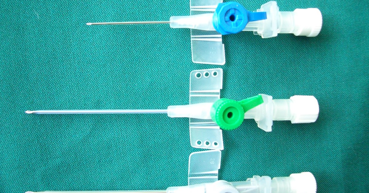 Cathéters veineux périphériques à embouts bleu et vert sur un champ opératoire vert