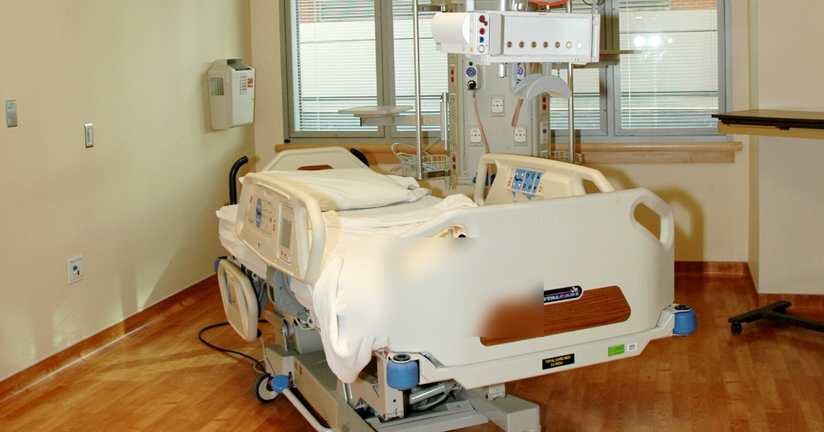 Quarto de internação vazio com leito hospitalar e monitor ao fundo