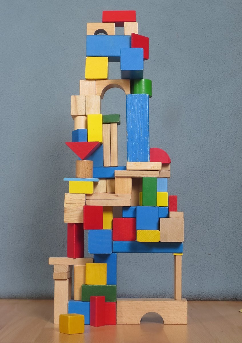 Torre de blocos de madeira empilhados sobre uma base estreita, com os blocos de cima mais largos que os de baixo