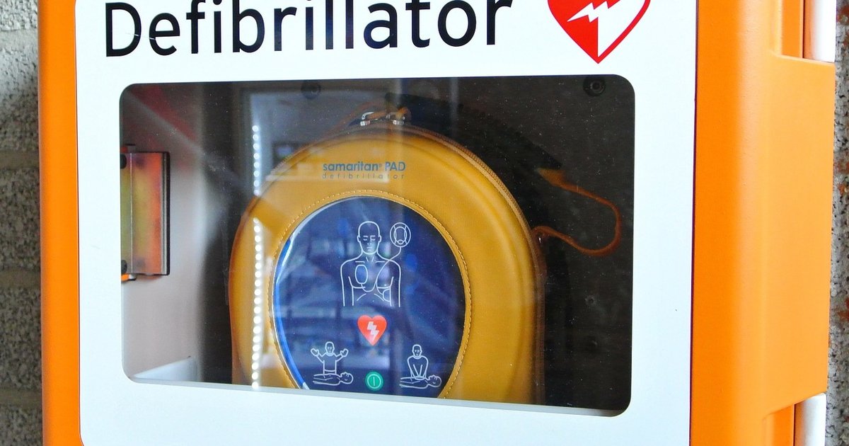 Automatischer externer Defibrillator in einem orangefarbenen Wandschrank