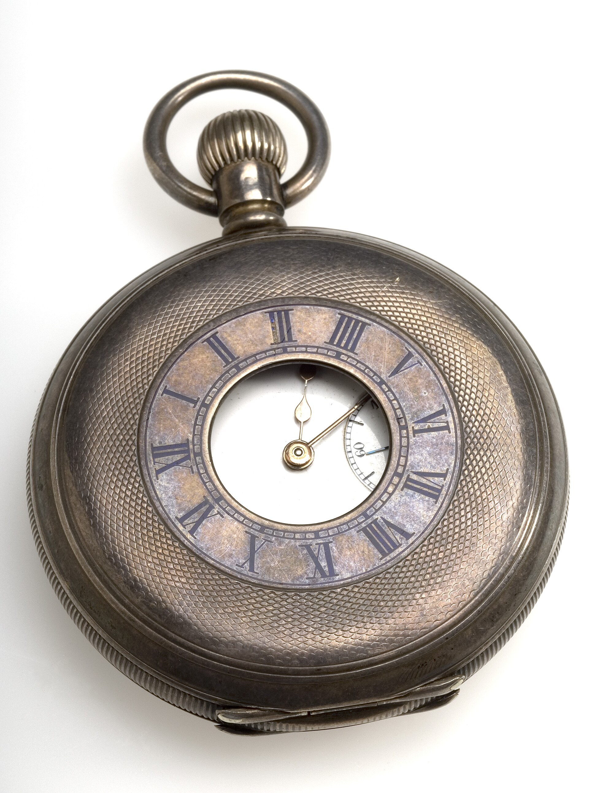 Silver half-hunter pocket watch, seen from the front on a white background: the lid engraved with a diamond pattern and a round window in the center, a ring of blue Roman numerals and, through the window, the gold hands and the small seconds dial.