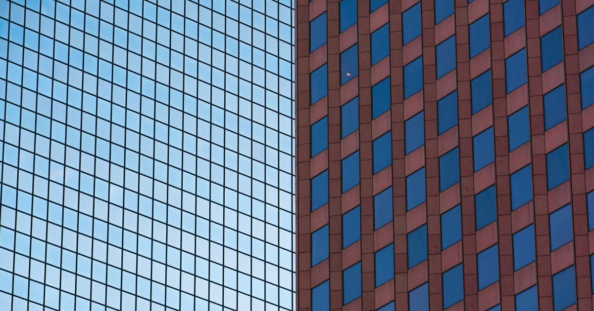 Zwei Gebäudefassaden mit regelmäßigen Fensterrastern, eine aus blauem Glas und eine aus roten Paneelen, in Boston.