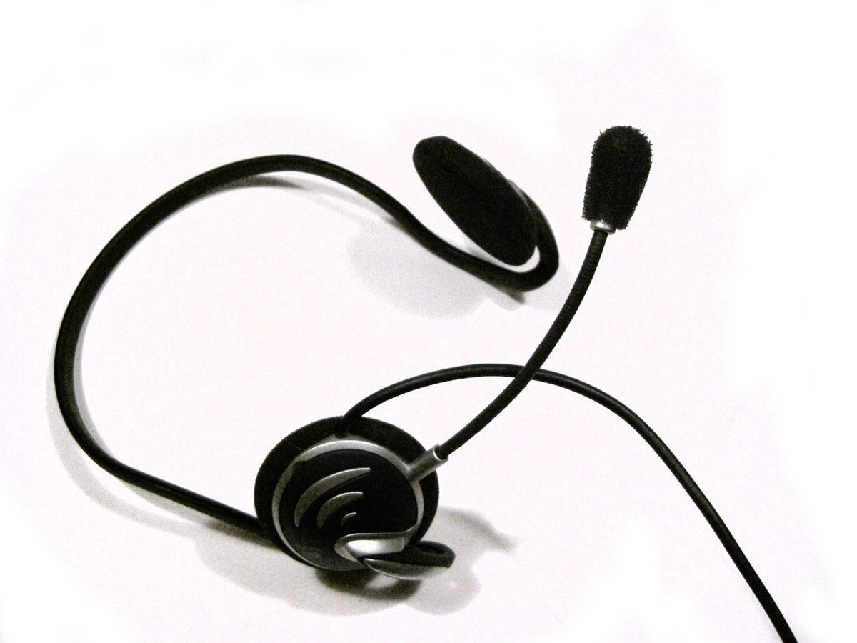 Fone de ouvido com microfone acoplado, apoiado sobre fundo branco